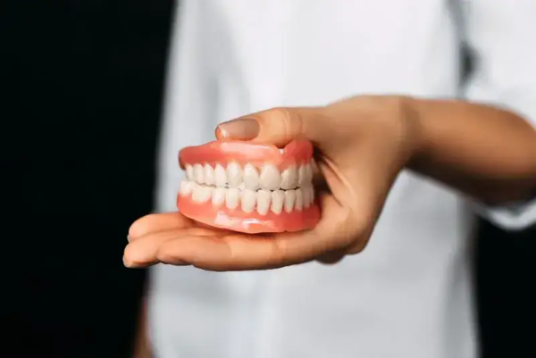 Female dentist holding full set of dentures